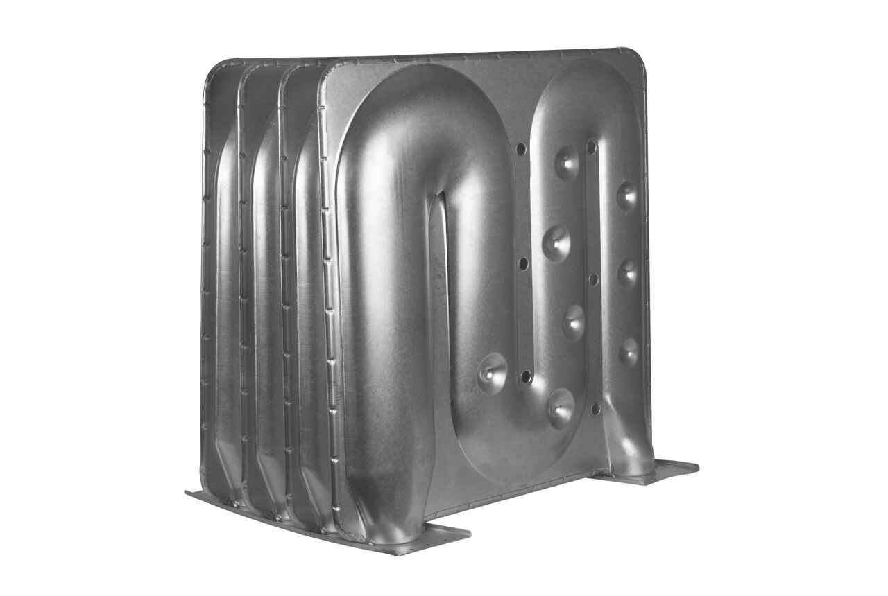 Metal heat exchanger with four parallel, curved channels. The surface has evenly spaced raised circular bumps and a smooth metallic finish. The structure stands upright on a flat base.